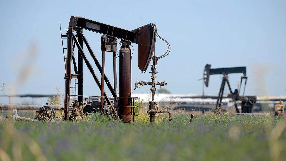 Oil pump jacks are visible in a Fresno County field in 2015. California filed a lawsuit Friday against oil companies including BP, Chevron and Shell for misleading the public about climate change.