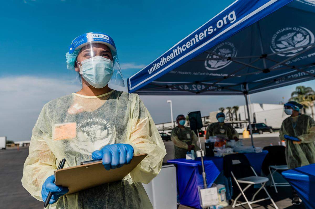 A United Health Centers worker prepares for farm laborers who are getting free COVID-19 testing during an event in October in Mendota, California.