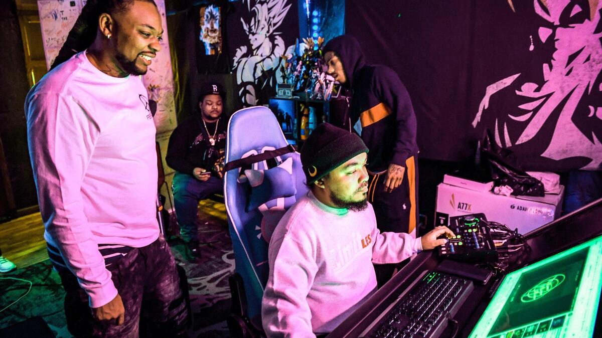 Local rapper Syrup, left, whose real name is Roger Brown, an Advance Peace “change agent,” watches as De’Andre Monia engineers a track performed by an Advance Peace fellow during a recording session in Fresno on Wednesday, March 17, 2021.