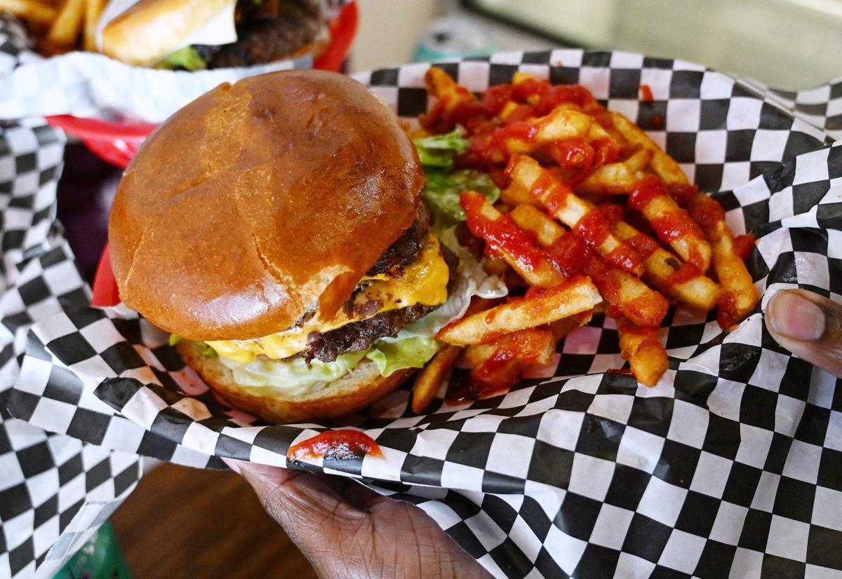 An All American Burger with fries is seen, one of many featured burgers from Take 3 x Grumpy Burger Lady’s on Fulton Street in downtown Fresno.