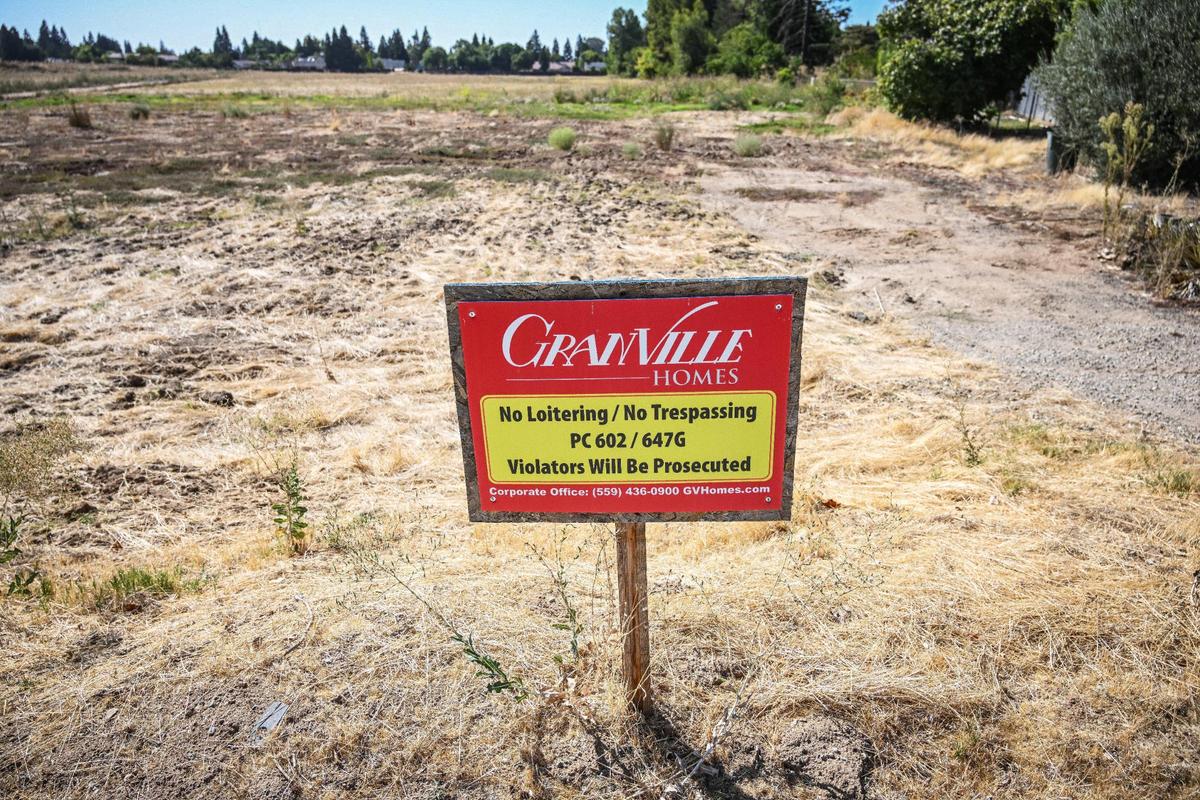 One of several “no trespassing” signs from Granville Homes stands on a vacant lot on Temperance Avenue near Nees in Clovis on Thursday, Sept. 28, 2023. A notice from the City of Clovis states that the lot is being considered for a proposed campus housing project for the Research and Technology Park.