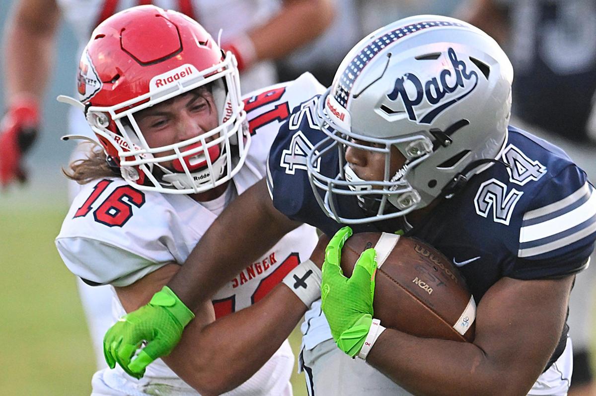 Clovis East’s Caleb Slocum, right, charges past Sanger’s Marshall Pittman, left, in the Silver Spear trophy game the Timberwolves won 42-21 Thursday, Aug. 31, 2023 in Clovis.
