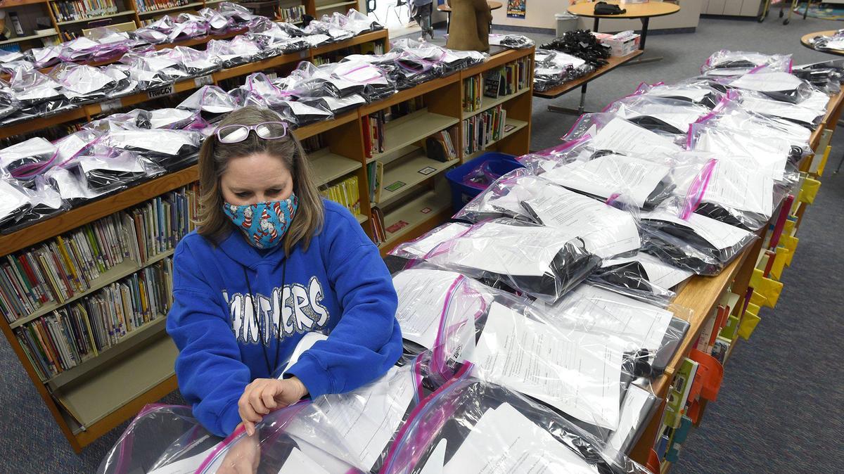 Addams Elementary School librarian Susanne Jung makes sure laptops and tablets have proper paperwork during during Fresno Unified’s distribution event at Addams, Wednesday April 22, 2020. The district is providing a laptop to every student in fourth through 12th grade and a tablet to every student in pre-k through third grade, to ensure that students stay connected during the COVID-19 pandemic closure. Addams is distributing a little over 900 devices to their students.