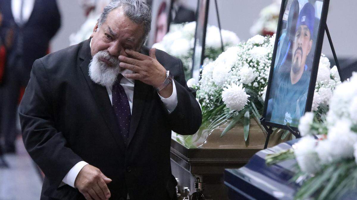 Reade & Sons Funeral Home worker Bob Arriaga gets emotional near the casket of Juvenal Jacobo Talavera, one of seven farmworkers who died in a Feb. 23 crash on a rural Madera County Road during a Mass and funeral service at the Kerman High School multi-purpose room on March 9, 2023.