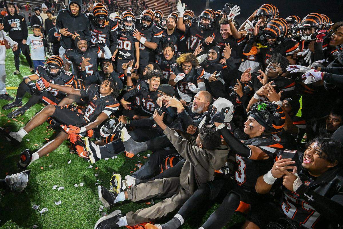 Members of the Central East football team celebrate and take photos after capturing the Central Section Division I-AA championship by defeating Clovis at Deran Koligian Stadium on Friday, Nov. 21, 2025.