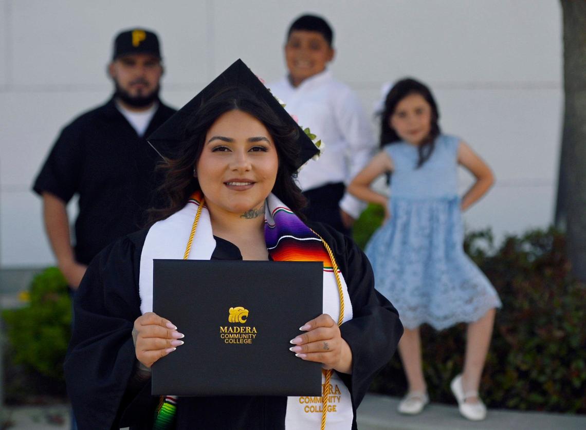 Madera Community College graduate Vanessa Barraza, with her family in the background, husband Jose Barraza, left, Julio Barraza, 10, center and daughter Lailani Barraza, 7, right. Photographed Tuesday, May 28, 2024 in Madera.
