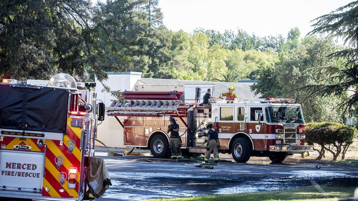 Firefighters prepare to leave the scene after extinguishing a tree fire near the In-Shape Health Club in the 2900 block of G Street in Merced, Calif., on Monday, June 20, 2022.