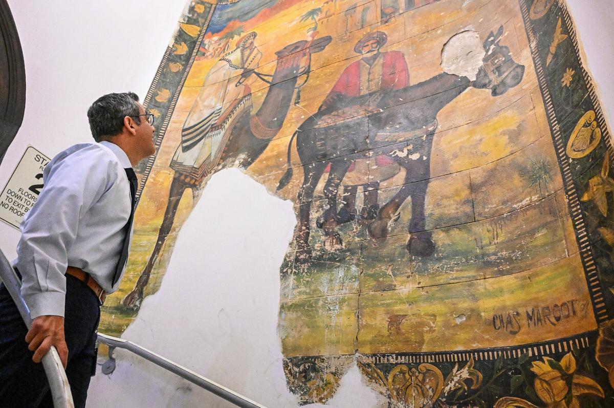 Fresno City Councilmember Miguel Arias looks over the stairway mural that survived decades of abandonment in the Hotel Fresno.