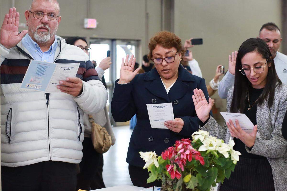Marco Antonio Álvarez, (left) and Araceli Santana (center) were some of the 99 valley residents from 23 countries who took Oath of Allegiance during a special public naturalization ceremony on Dec. 30 at the Fresno Fairgrounds during the Hmong Cultural New Year Festival.