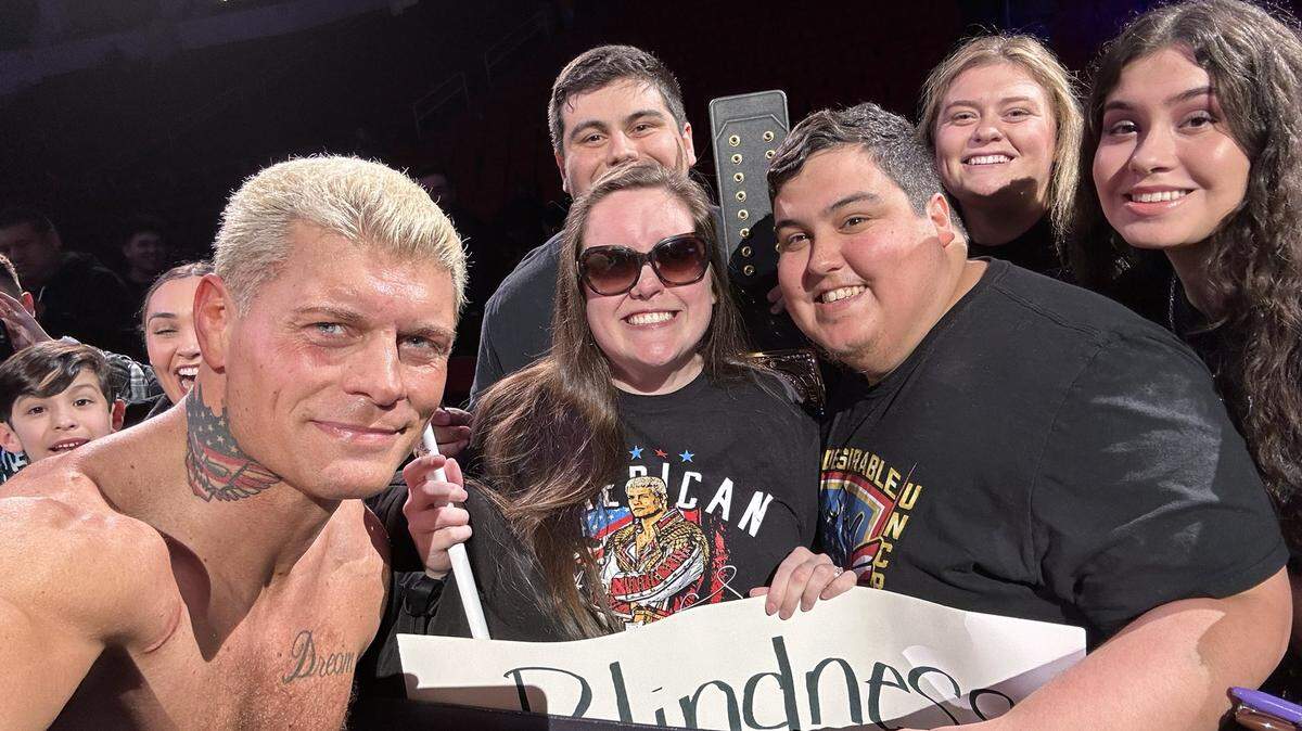 Cody Rhodes holds Tyler Avila’s phone and takes a selfie with Shaela Avila and her family.