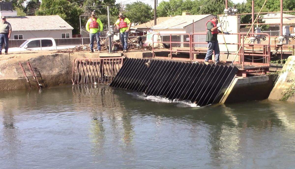 Irrigation workers helped slow the flow and lower the water level while also clearing debris in a Fresno canal on Friday, June 4, 2021, as rescue teams continued efforts to locate 38-year-old Fannie Chindapheth of Fresno. She fell into the canal Wednesday.