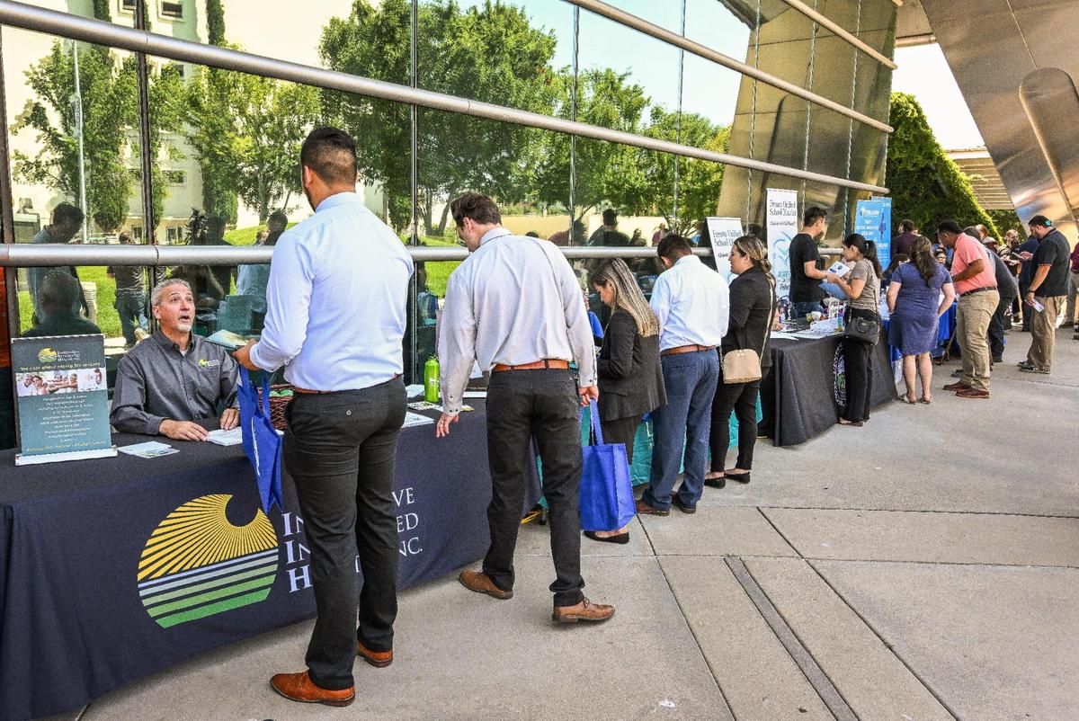 Job-seekers stop to speak with dozens of prospective employers during a job fair hosted by Workforce Connection and the City of Fresno in response to the laying off of 300 Fresno employees from Bitwise Industries, at Fresno City Hall on Friday, June 16. 2023.