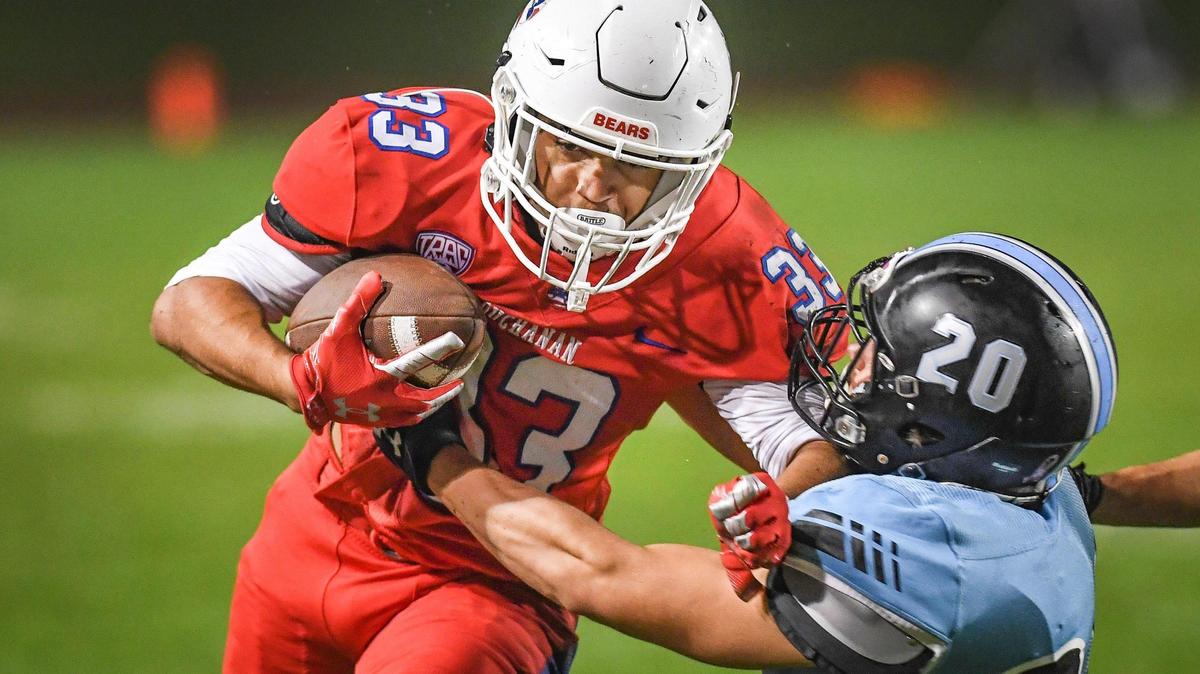 Buchanan’s Michael Runnels, left, pushes past Clovis North’s Vincent Cordoba on a run down the sideline during their quarterfinal playoff game at Veterans Memorial Stadium in Clovis on Friday, Nov. 12, 2021.