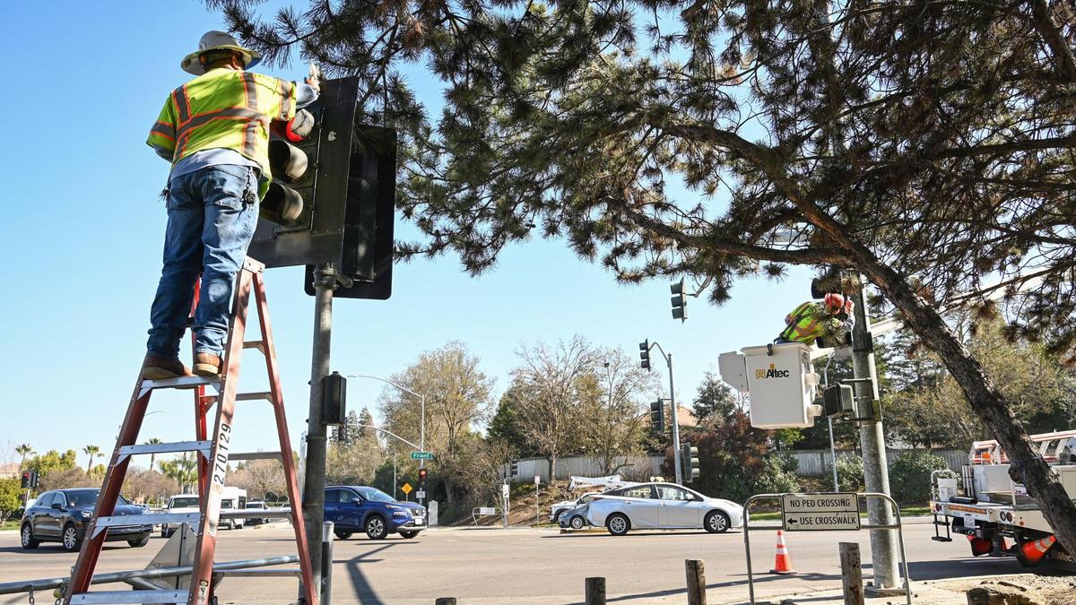 City of Fresno crews work to install reflective backplates to the traffic signals at Friant Road at Fort Washington near Woodward Park in Fresno on Thursday, Feb. 10, 2022. The intersection and other areas in front of the park have become a concern for safety after recent deaths from passing vehicle traffic.