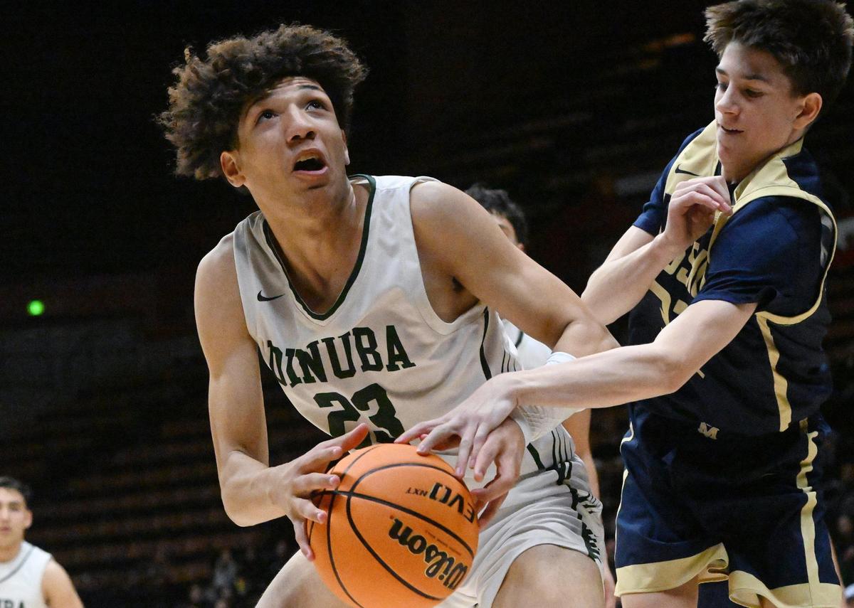 Mission Prep’s Brody Miller, right, gets a hand on Dinuba’s Brice Watley, left, and in the Division II game Friday, Feb. 23, 2024 in Fresno..