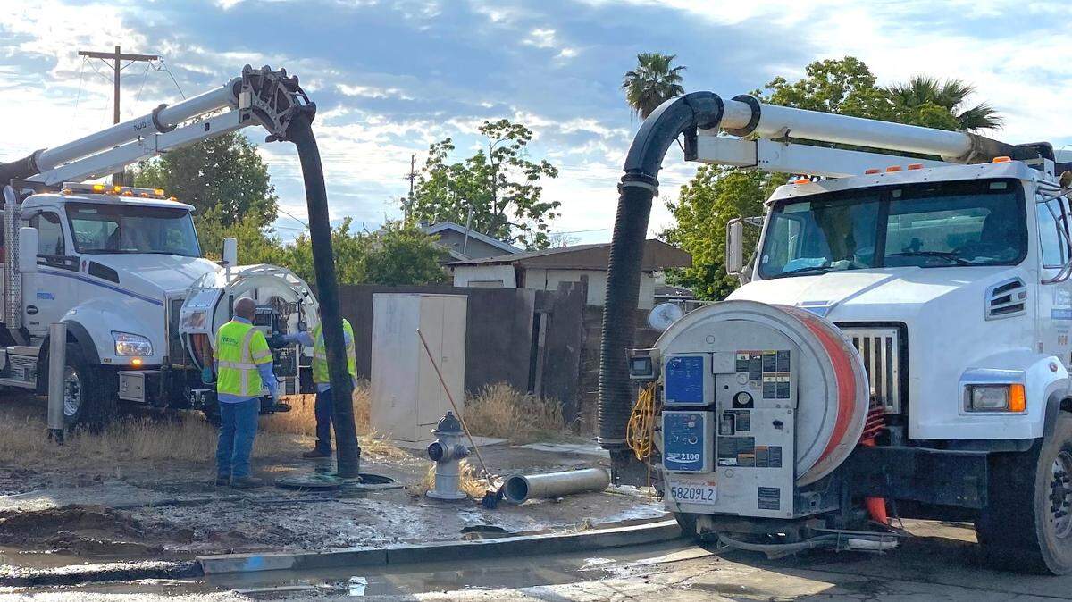 Public utilities crews for the city of Fresno pump sewage from an underground pipeline into trucks to move material around a break in the system on Saturday morning, May 6, 2023. The broken line was reported Friday night.