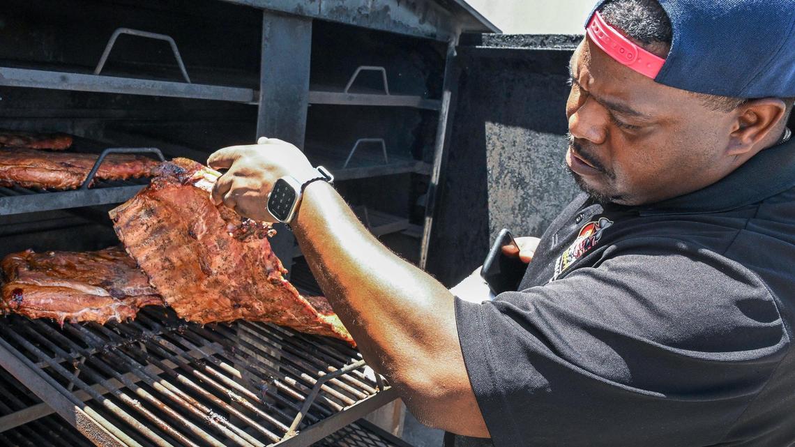 Herman Tatum, owner of Hogg Pitt BBQ & Catering, checks on barbecue pork ribs on the smoker at his new brick-and-mortar restaurant in Fresno on Monday, June 2, 2025.