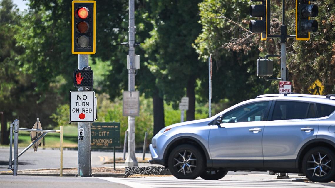 Traffic crosses the intersection at Fort Washington and Friant Road where no right turn on red signs have been installed on Monday, Aug. 5, 2024. Several safety measures have been implemented along a dangerous section of Friant Road in north Fresno including high-visibility crosswalks, reflective signal backplates, and no right turn on red signs.