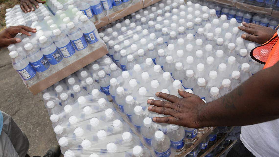 Workers wait to hand out water to Flint, Mich., residents from a distibution site at St. Mark Missionary Baptist Church in Flint’s north side on August 5, 2016.