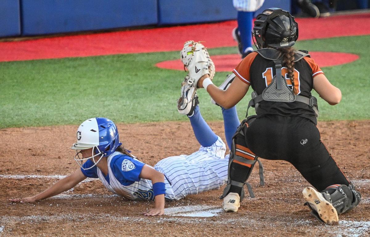 Clovis’ Ashley Rocha dives past the tag of Central catcher Amara Klein at home plate during their Central Section Division I softball championship game at Margie Wright Diamond on Saturday, May 28, 2022.