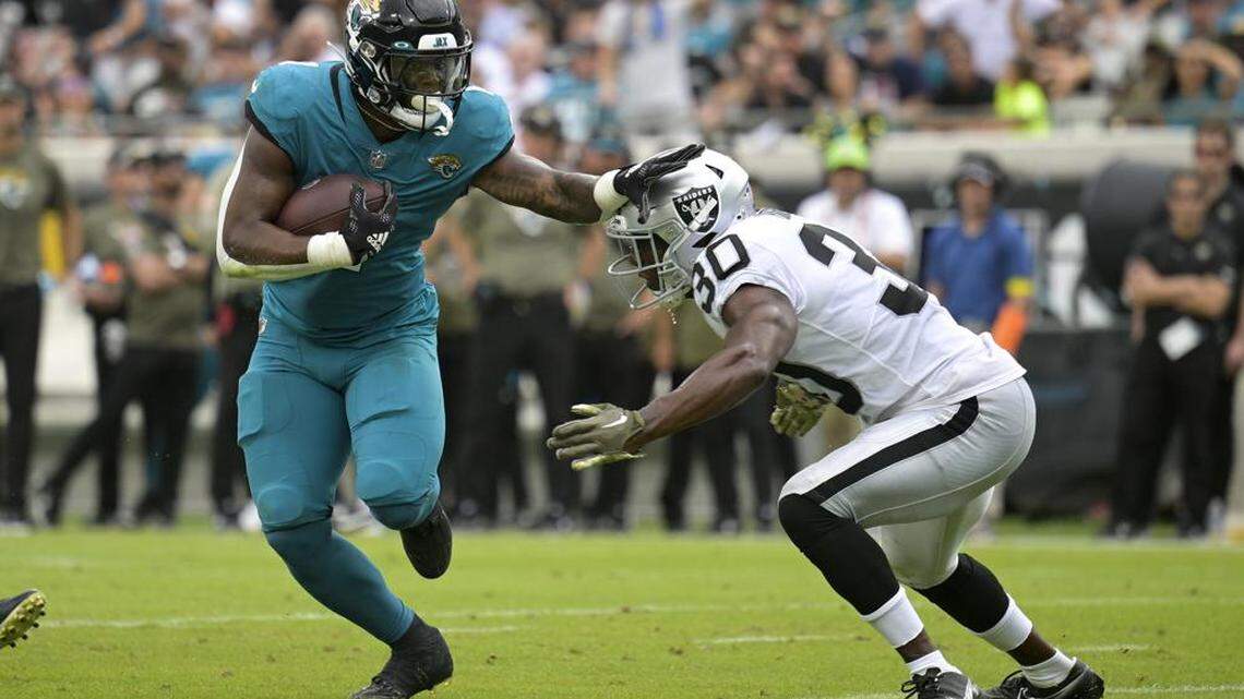 Jacksonville Jaguars running back Travis Etienne Jr. tries to get past Las Vegas Raiders safety Duron Harmon in the first half of an NFL game Sunday, Nov. 6, 2022, in Jacksonville, Fla.
