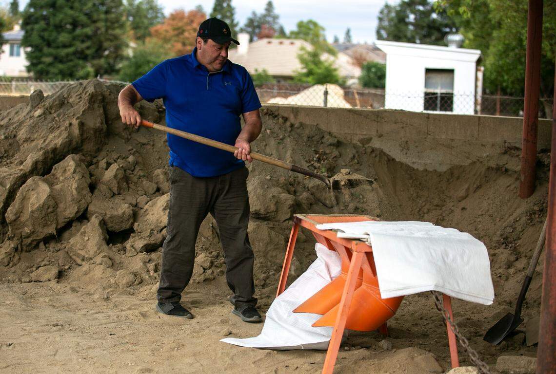Kyle Sedra fills up a sandbag Sunday Oct. 24, 2021, at a county yard location in north Fresno to hopefully help prevent his home from flooding as a major winter storm bears down on the central San Joaquin Valley.