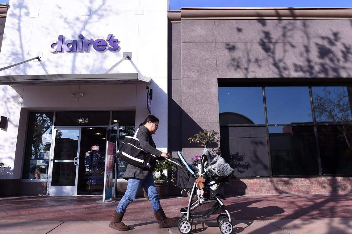 A woman pushes a baby stroller past the Claire's in River Park in this file photo from 2017.