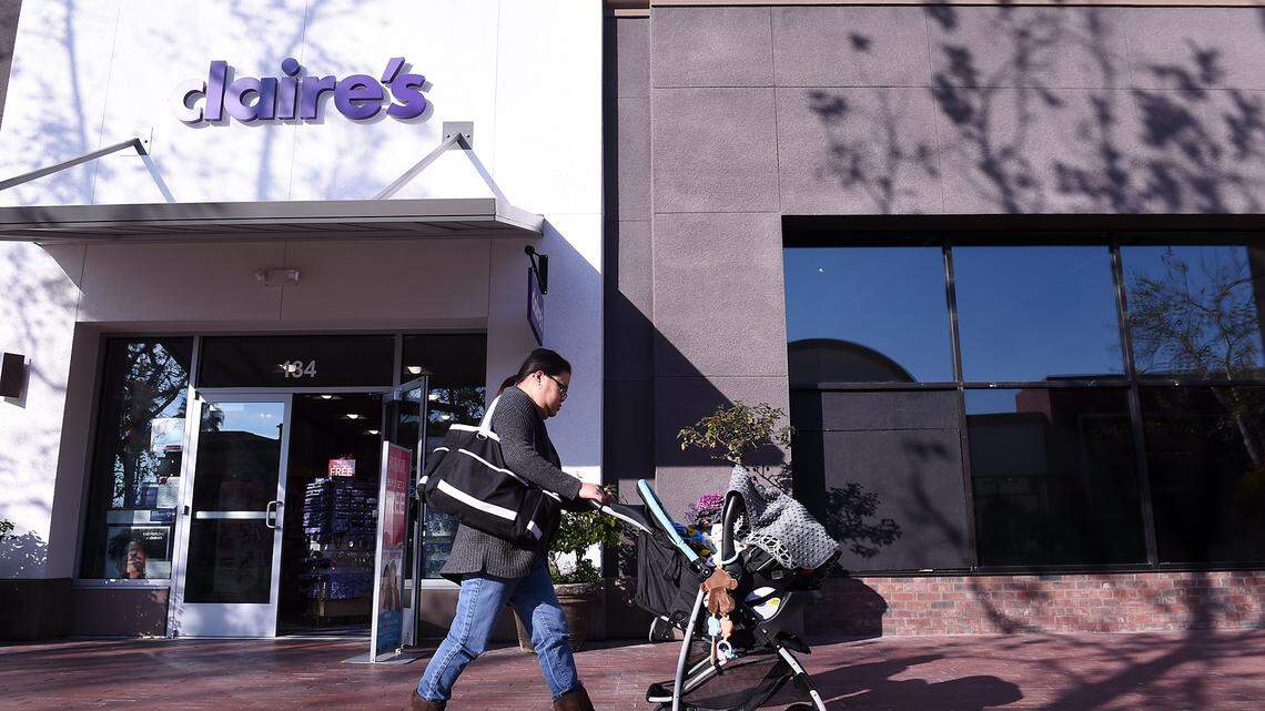 A woman pushes a baby stroller past the Claire's in River Park in this file photo from 2017.