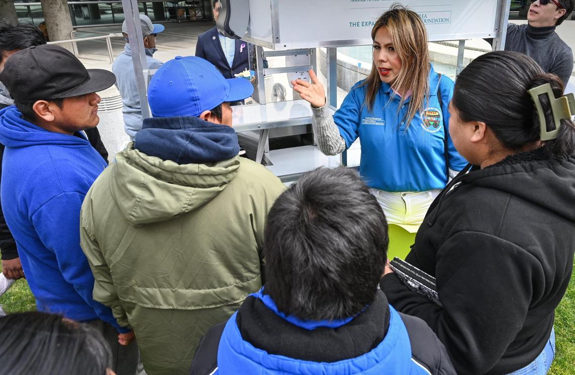 Carmela Flores, right center, of the Asociación de Vendedores Ambulantes de Fresno gives information to area food vendors on a new food cart prototype that meets permitting standards of the Fresno County Health Department during an unveiling event at Fresno City Hall on Thursday, March 9, 2023.
