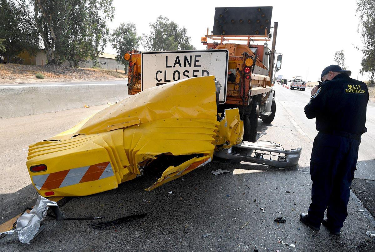 An investigator photographs a Caltrans attenuator truck struck by a small sedan Saturday morning, Aug. 14, 2021, triggering a multiple-vehicle crash on Highway 99, according to the CHP, resulting in one death and closing the southbound lanes near Herndon Avenue.