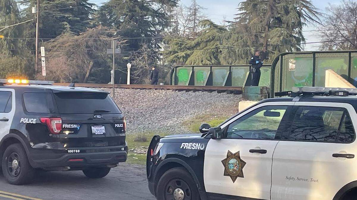 Fresno police officers secure crime scene after a body was found on the bridge over Van Ness Avenue in the Fig Garden area.