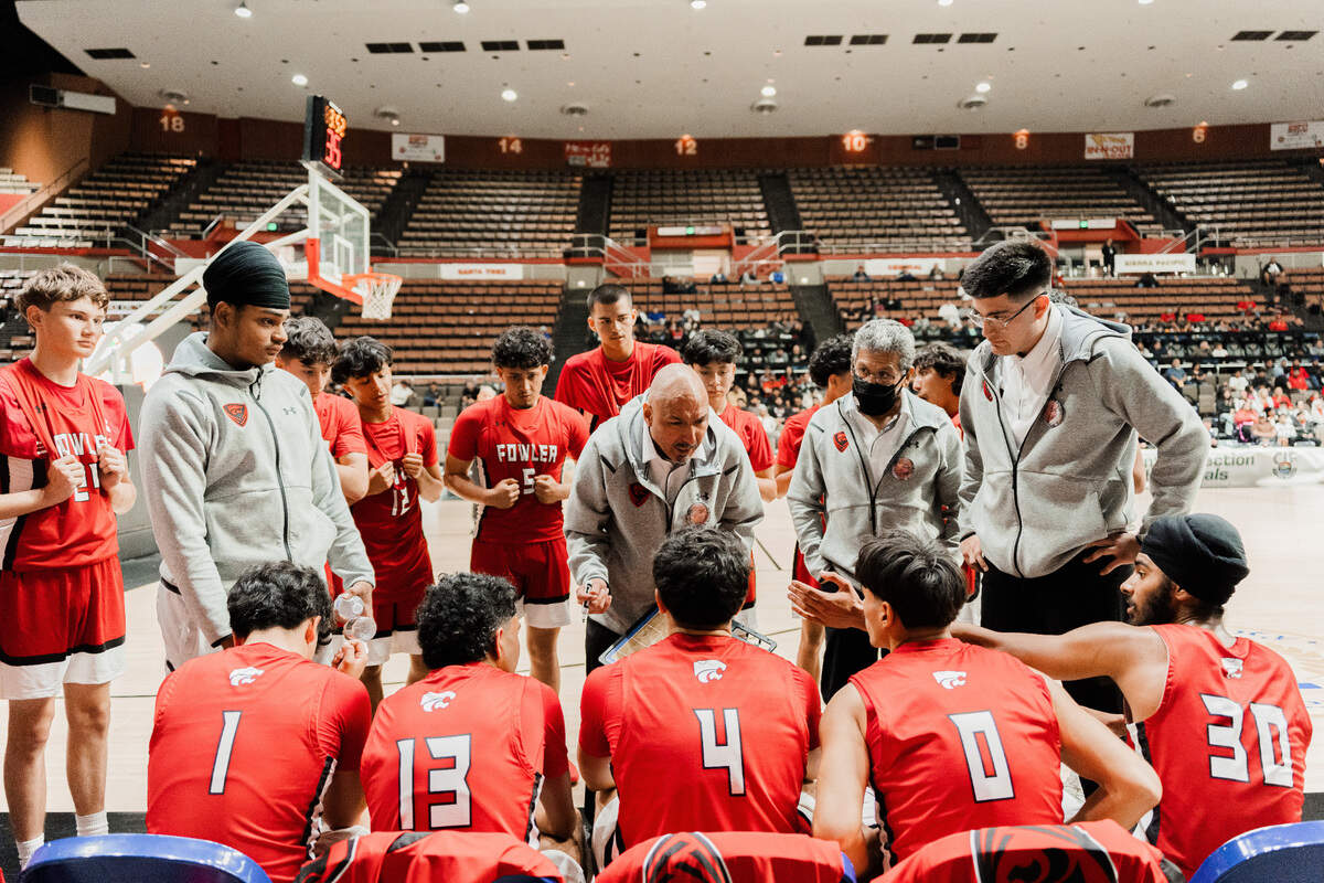 Fowler High coach Alfonso Alvarado talks to his team during a timeout.