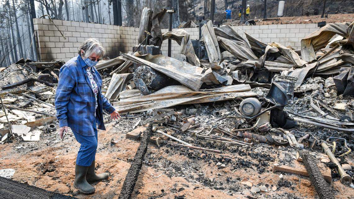 Gloria Sprague looks over the damage to her home on Auberry Road near Alder Springs on Tuesday, Sept. 22, 2020. Residents who lost their homes in the Creek Fire were being allowed to return to survey the damage and salvage any items.