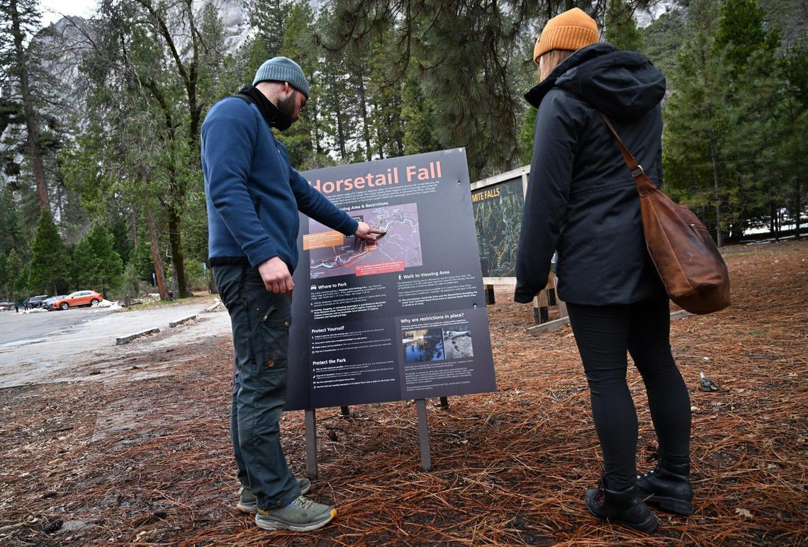 Visitors from Ireland interested in viewing the annual firefall read an informational post located near Yosemite Lodge in Yosemite Valley Friday, Feb 9, 2024, in Yosemite National Park.