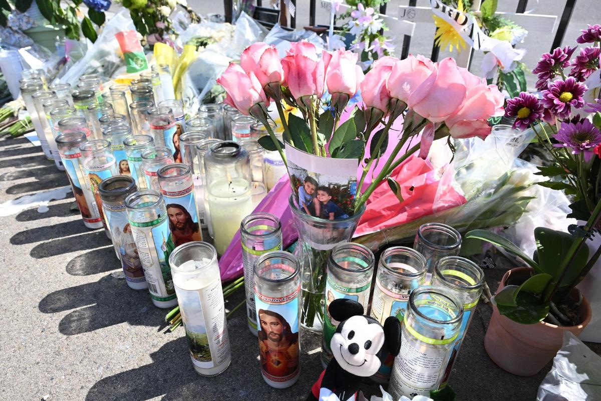 Flowers, candles and photographs pay tribute to the victims of a fiery crash that occurred on Friday, May 2 at Clovis Avenue at Shields in Fresno appear in a memorial left at the scene, on Monday, May 5, 2025.