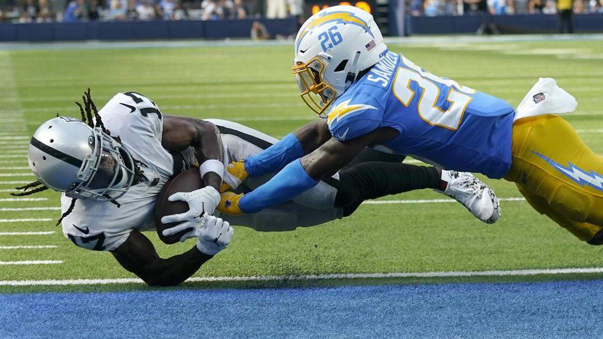 Las Vegas Raiders wide receiver Davante Adams, left, scores a touchdown against Los Angeles Chargers cornerback Asante Samuel Jr. during the second half of an NFL football game in Inglewood, Calif., Sunday, Sept. 11, 2022.