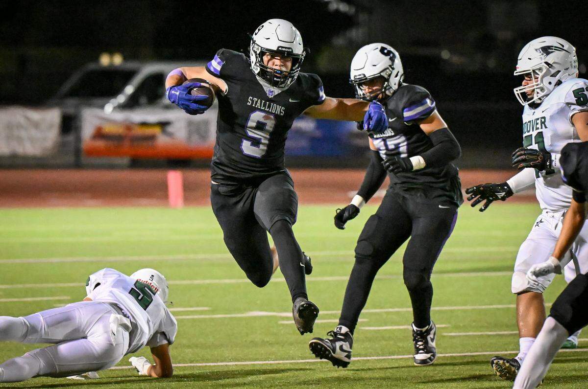 Madera South's Camaron Hamilton, center, leaps over diving players on a run up the middle against Hoover during their game at Madera South Stadium on Friday, Sept. 19, 2025.