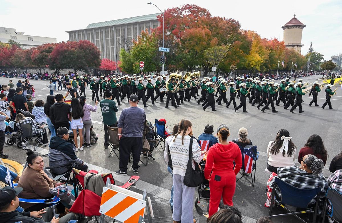 Parade-watchers take in the sights and sounds as Roosevelt High School’s marching band turns the corner at Fresno and P street during the 105th annual Central Valley Veterans Day Parade in downtown Fresno on Monday, Nov. 11, 2024.