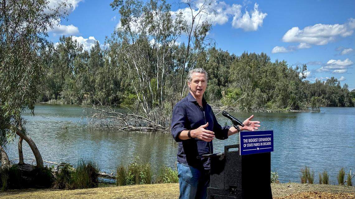 California Gov. Gavin Newsom announces the expansion of the state park system during a news conference near the Sycamore Island fishing dock along the San Joaquin River Parkway in Madera County on Wednesday, April 22, 2026.