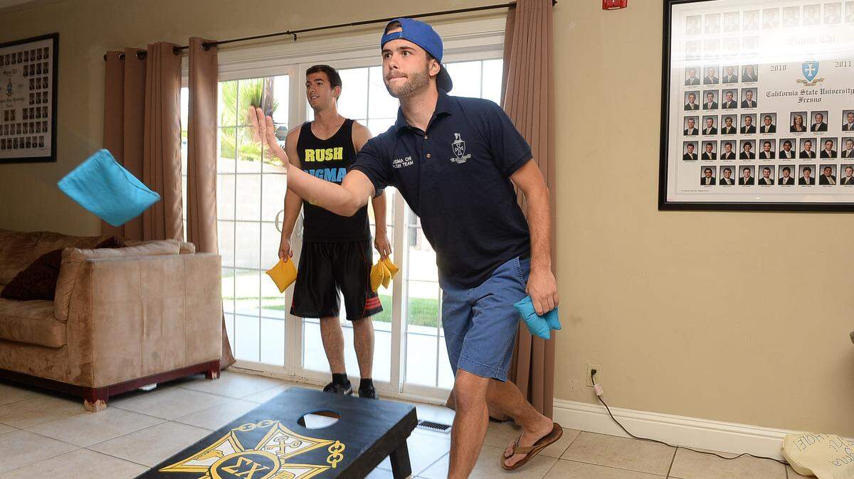 In this file photo from 2013, John Savage, right, and Brandon Teicheira play a game of cornhole at the Sigma Chi fraternity house at Fresno State.