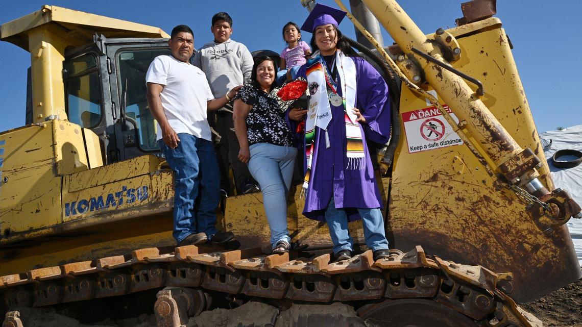 Elizabeth Gonzales-Cortes, 18, right, poses with her family left to right, father Manuel Ruiz, and mother Crispina Gonzales, with siblings Emilio Ruiz, 16 and Yazmin Ruiz, 3 in the far background. Photographed Friday, May 17, 2024 outside of Madera. Elizabeth is graduating from Madera South High School, headed to UC Irvine, a biology major and pre-med.