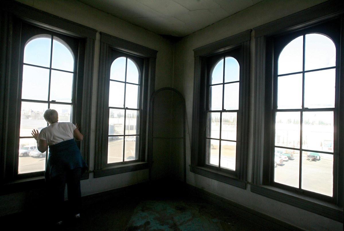 Martha Eaves, assistant to the owner of the old Fresno Brewing Co., Pat Haun, looks out of one of the many arched upstairs windows in the building in this Fresno Bee file photo.