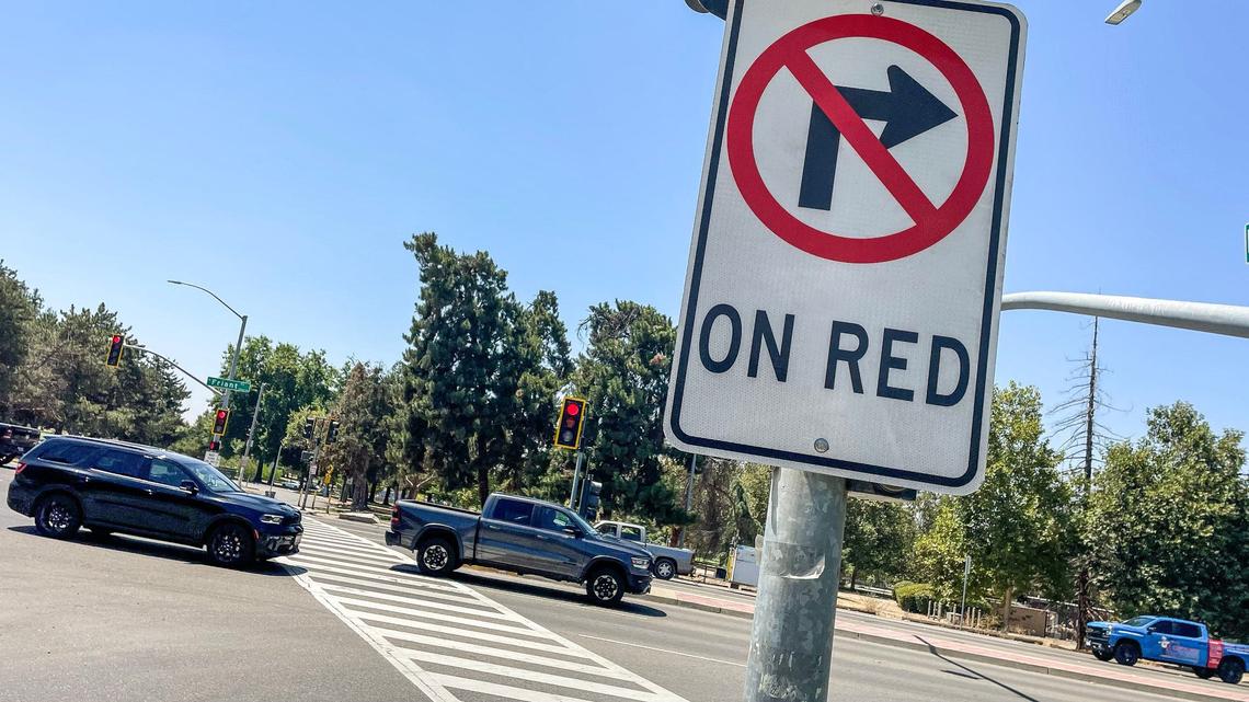 Traffic crosses the intersection at Fort Washington and Friant Road where no right turn on red signs have been installed on Monday, Aug. 5, 2024. Several safety measures have been implemented along a dangerous section of Friant Road in north Fresno including high-visibility crosswalks, reflective signal backplates, and no right turn on red signs.