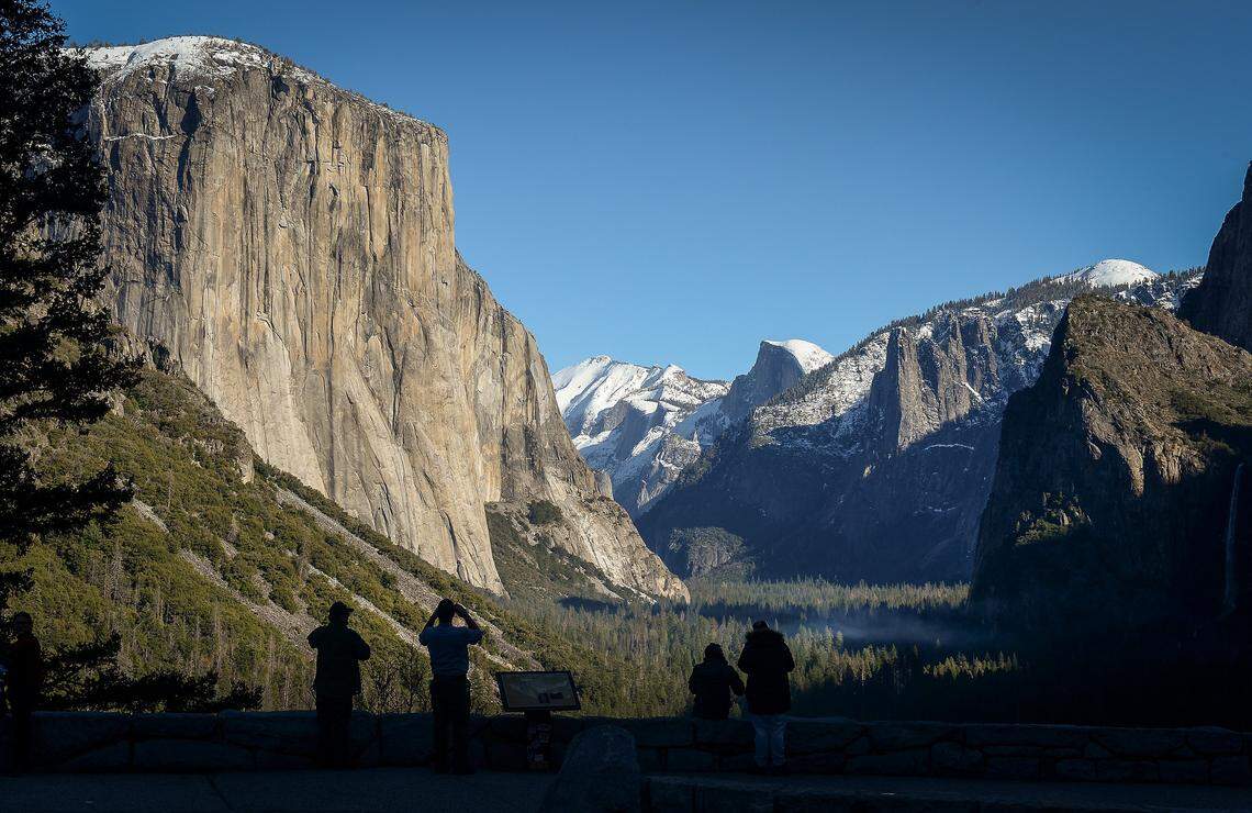 A few park visitors stop to see El Capitan, left, and Half Dome from Tunnel View in Yosemite National Park after snow dusted the area on Monday, Dec. 9, 2019.