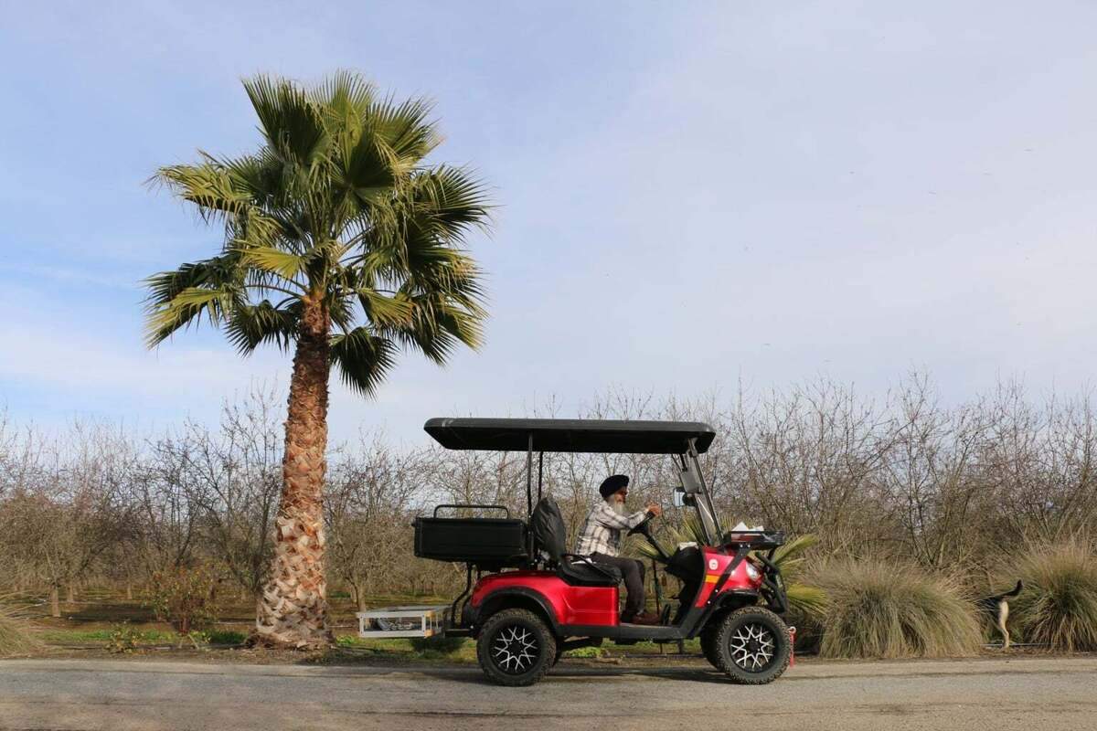 Amrik “Mickey” Singh Basra drives a golf cart on his farm.