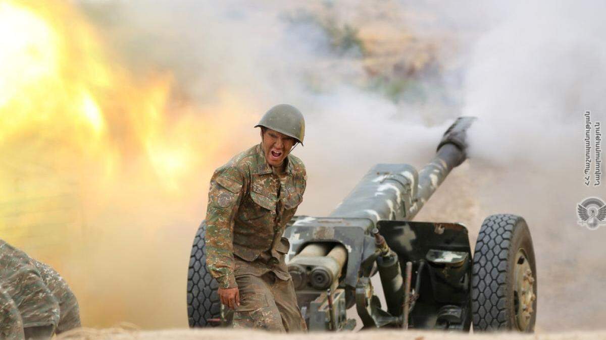 An Armenian soldier fires a cannon during the conflict with Azerbaijan forces.