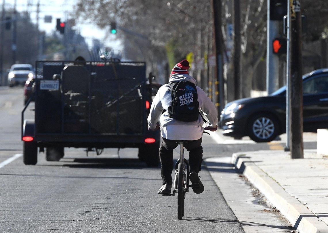 A cyclist shares the roadway with cars on Palm Avenue north of Clinton Avenue on Feb. 16, 2022. A bike path will be installed this summer on much of Palm, reducing motor vehicle traffic to one-lane in each direction.