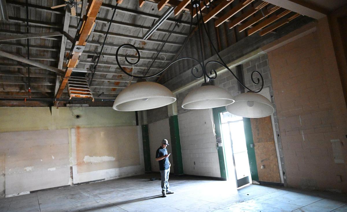 A lighting fixture is seen inside Mecca Billiards as Ivan Torres stands with his phone Monday, July 14, 2025 in Fresno. New co-owners Shamsher Singh and Tony Singh said they hope to re-open Mecca Billiards in Fresno’s Brewery District later this year as Sierra Billiards if all goes as planned.