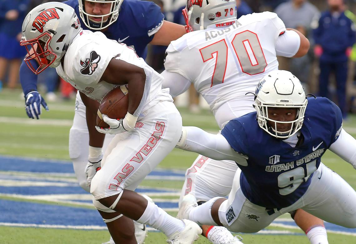 UNLV running back Charles Williams (8), a Bullard High grad, runs through a tackle by Utah State defensive end Devon Anderson (91) in the Rebels’ 59-28 loss to the Aggies Saturday, Oct. 13, 2018, in Logan, Utah. Williams is averaging 4.2 yards on 40 carries this season.