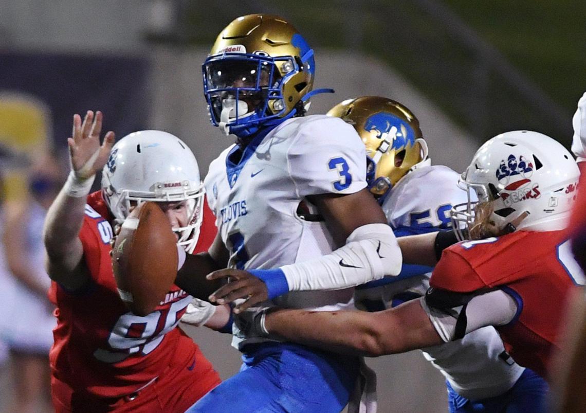 Buchanan’s Drew Washburn, left, and Gavin Nelson, right, swarm Clovis High quarterback Nate Johnson, center, Thursday, April 1, 2021 in Clovis.